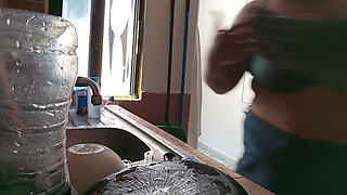 Mother-in-law cleans in the kitchen in bra