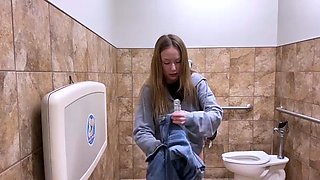 Wild teen gets herself off with a sex toy in a public toilet